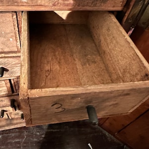 May include: A wooden drawer with a black metal handle. The drawer is labeled with the number "3".