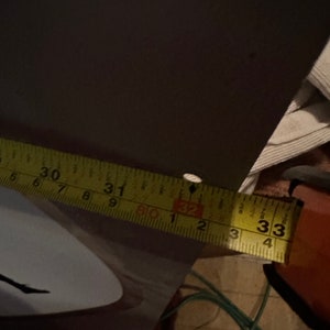 May include: A yellow measuring tape with black markings, showing the numbers 30, 31, 32, and 33 inches.