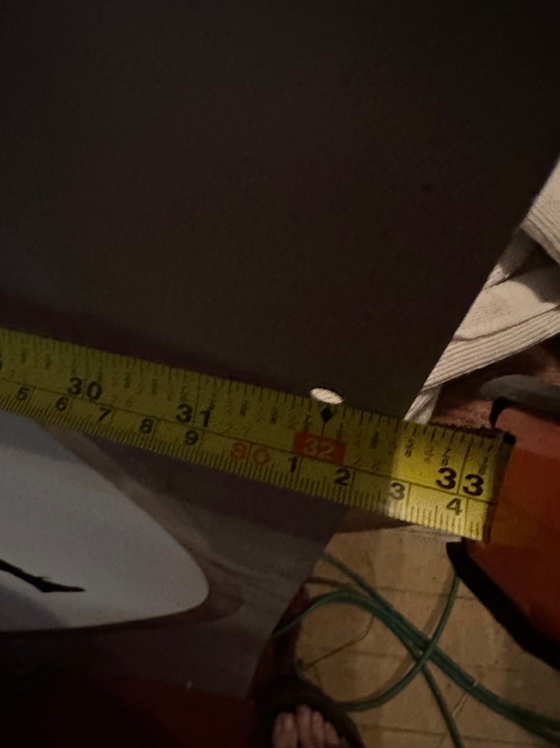 May include: A yellow measuring tape with black markings, showing the numbers 30, 31, 32, and 33 inches.