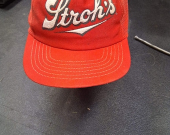 Gorra de camionero vintage de malla roja con cierre ajustable de la marca de cerveza Stroh's. Publicidad de la cervecería en EE. UU.
