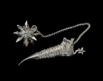 May include: A silver chain necklace with a silver star-shaped pendant and a silver spiked ball pendant.