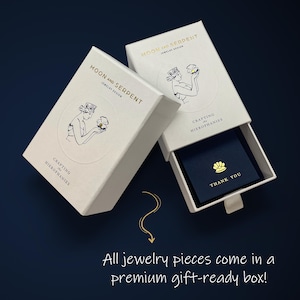 May include: White box with gold lettering that reads "Moon and Serpent Jewelry Design" and "Crafting in Hierophanies". The box is open and shows a smaller blue box with gold lettering that reads "Thank You".