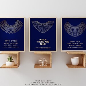 May include: Three 8.5x11 inch prints with gold foil accents on a dark blue background. Each print features a gold outline of the iconic RBG collar and a quote from Ruth Bader Ginsburg. The quotes are: "Women belong in all places where decisions are being made."  "When there are nine."  "Speak your mind even if your voice shakes."