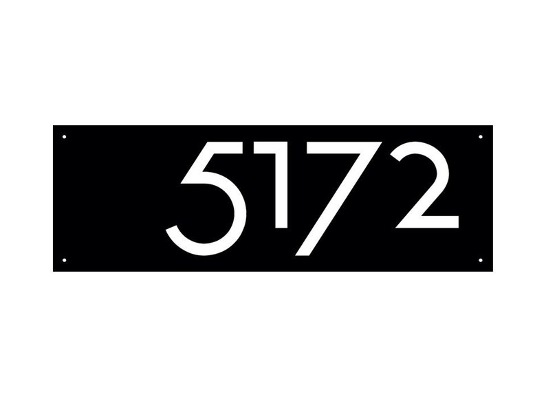 May include: A black rectangular address sign with the white numbers "5172". The numbers are in a modern font. The sign has four small holes, one in each corner.