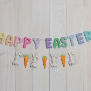 May include: A pastel-colored felt banner with the words "Happy Easter" and bunny and carrot decorations.