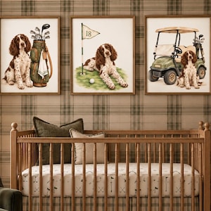 Könnte beinhalten: Drei gerahmte Wandbilder mit einem braun-weißen Spaniel, Golfausrüstung, einer mit 18 beschrifteten Golffahne und einem Golfcart. Die Bilder hängen über einem hölzernen Kinderbett mit kariertem Bettvolant und einem Laken mit Golfmotiven.
