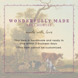 K&ouml;nnte beinhalten: Eine digitale Grafik mit dem Text WONDERFULLY MADE BABY MOBILES und made with love, &uuml;berlagert auf einem pastoralen Landschaftsgem&auml;lde, das eine braune Kuh, einen gefleckten Hund und mehrere Schafe auf einem Feld zeigt, umrahmt von einem violetten Rand.