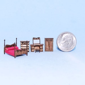 May include: A miniature wooden bedroom furniture set, including a bed with a red mattress, a dresser, a vanity with a mirror, and a wardrobe. The set is shown next to a US dime for scale.