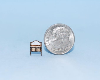 Könnte beinhalten: Miniatur-Holzkommode mit weißem, gewölbtem Spiegel und zwei Schubladen. Die Kommode ist braun mit heller Holzmaserung. Eine amerikanische 10-Cent-Münze liegt daneben, um die geringe Größe der Möbel zu verdeutlichen.