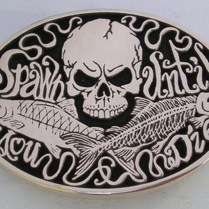 May include: A silver belt buckle with a black background. The buckle features a skull with two fish, one whole and one skeletonized, with the text "Spawn Until You Die" around the edge.