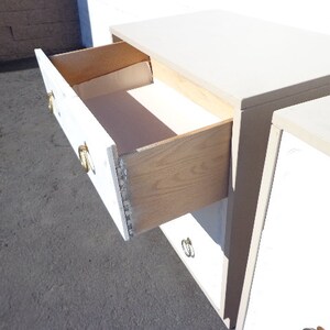 May include: White dresser with four drawers and gold-toned hardware. The top drawer is open, revealing a wooden interior.