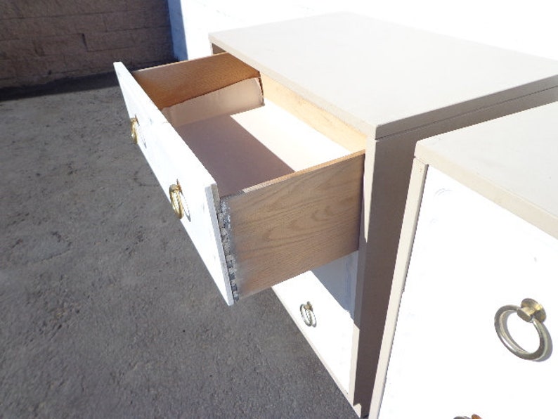 May include: White dresser with four drawers and gold-toned hardware. The top drawer is open, revealing a wooden interior.