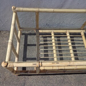 May include: A natural bamboo coffee table with a glass top. The table has a rectangular shape and is made of woven bamboo.