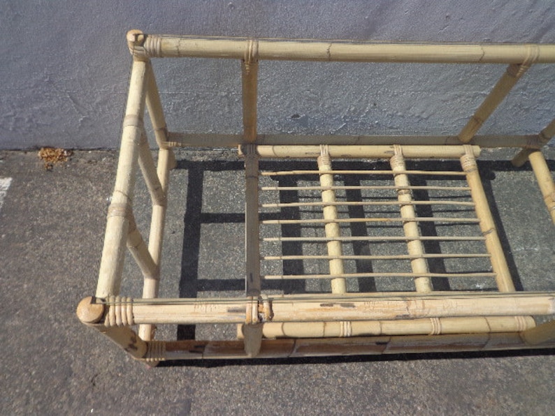 May include: A natural bamboo coffee table with a glass top. The table has a rectangular shape and is made of woven bamboo.