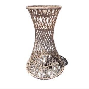 May include: A white wicker end table with a round top and a flared base. The table is made of woven wicker and has a natural finish.