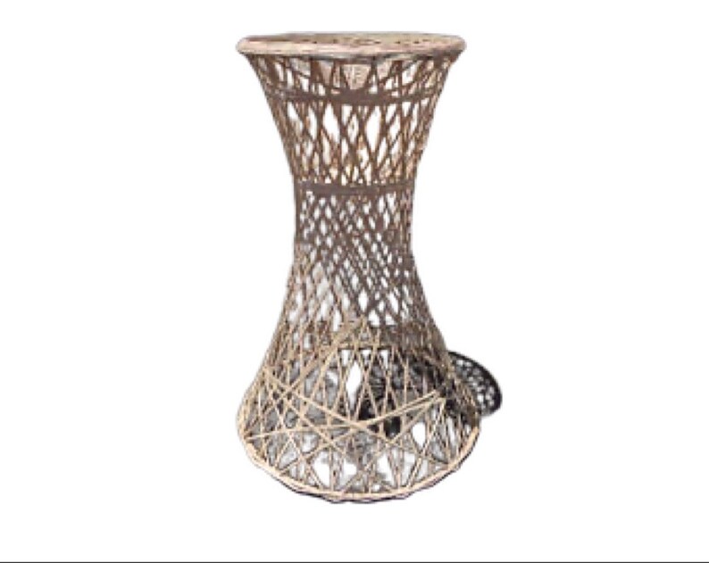May include: A white wicker end table with a round top and a flared base. The table is made of woven wicker and has a natural finish.