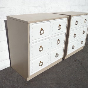 May include: Two white and beige dressers with gold ring pulls. Each dresser has five drawers.