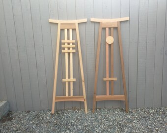 May include: Two wooden trellises, one with a simple design and the other with a more intricate design, both with a curved top and a light brown finish.