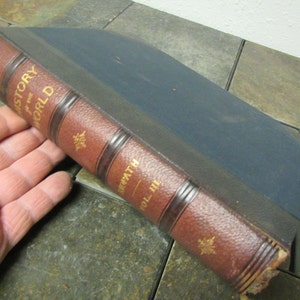 May include: A brown leather-bound book with gold lettering on the spine. The title is "History of the World" by "H.E.  Swath" and the volume is "Vol. III".