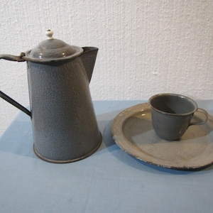 May include: A gray enamelware coffee pot with a white knob on the lid, a gray enamelware cup, and a gray enamelware plate.