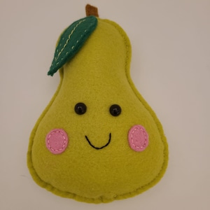 May include: A green felt pear with a smiling face, black eyes, and pink cheeks. The pear has a green felt leaf on top.