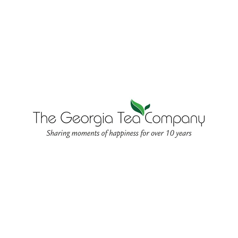 May include: The Georgia Tea Company logo on a white background. The logo features the company name in a black, elegant font, with a green leaf design. Below the name is the tagline, "Sharing moments of happiness for over 10 years."