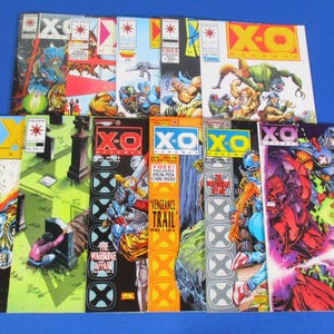 以下が含まれることがあります： Valiant ComicsのX-O Manowarコミックブック10冊セット。アクションシーン、キャラクターの肖像画、太字の黄色や赤のタイトルが描かれた、色鮮やかなイラストの表紙が特徴です。コミックは青い表面に2列に並べられています。