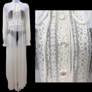 May include: White sheer lace robe with long sleeves and a tie at the neck. The robe has a heart-shaped button closure.