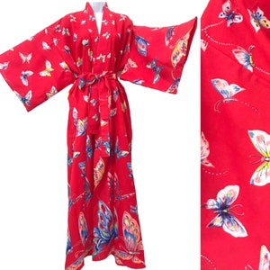 Puede incluir: Una bata de kimono roja con estampado de mariposas. La bata tiene mangas largas y un cinturón de atar.