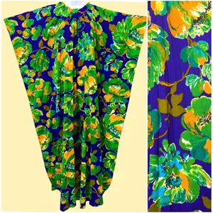 May include: A floor-length kaftan featuring a vibrant floral pattern with large orange, lime green, and teal flowers set against a deep purple background. The garment has a gathered round neckline and wide, flowing sleeves that create a loose silhouette.