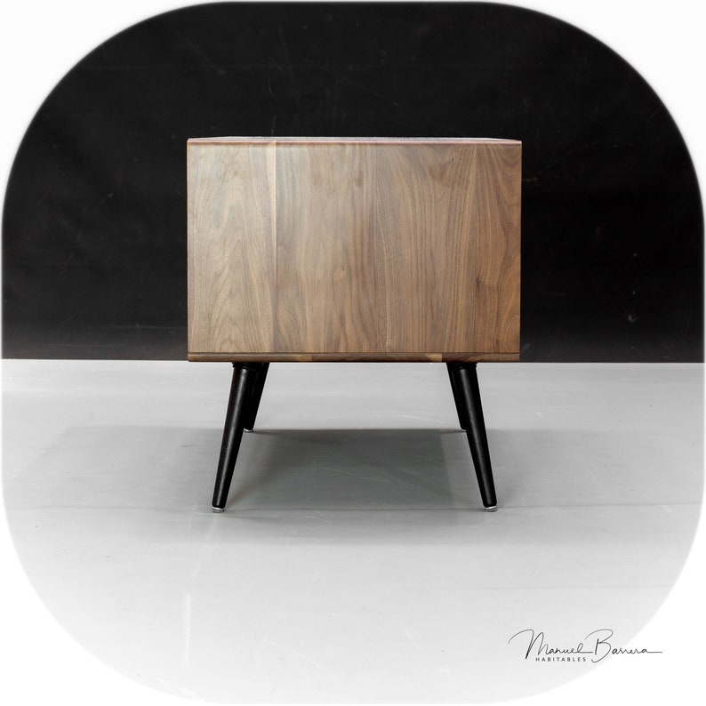 May include: A wooden side table with a walnut finish and black tapered legs. The table has a single drawer.