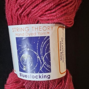 May include: A skein of red hand-dyed yarn labeled "String Theory" and "Bluestocking".