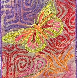 May include: A colorful embroidered butterfly with yellow, pink, and orange accents is set against a background of swirling purple, red, and orange lines.