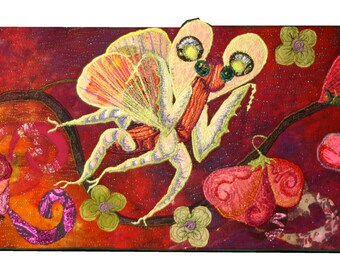May include: A colorful textile art piece featuring a whimsical insect-like creature with large eyes and wings, surrounded by stylized flowers and foliage. The artwork uses a palette of reds, oranges, greens, and yellows, creating a vibrant and imaginative scene.