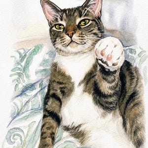 A watercolor painting of a brown and black tabby cat with a white chest and paws. The cat is reaching forward with one paw raised. The name Skittles is written in cursive at the bottom center, with a signature in the bottom right corner.