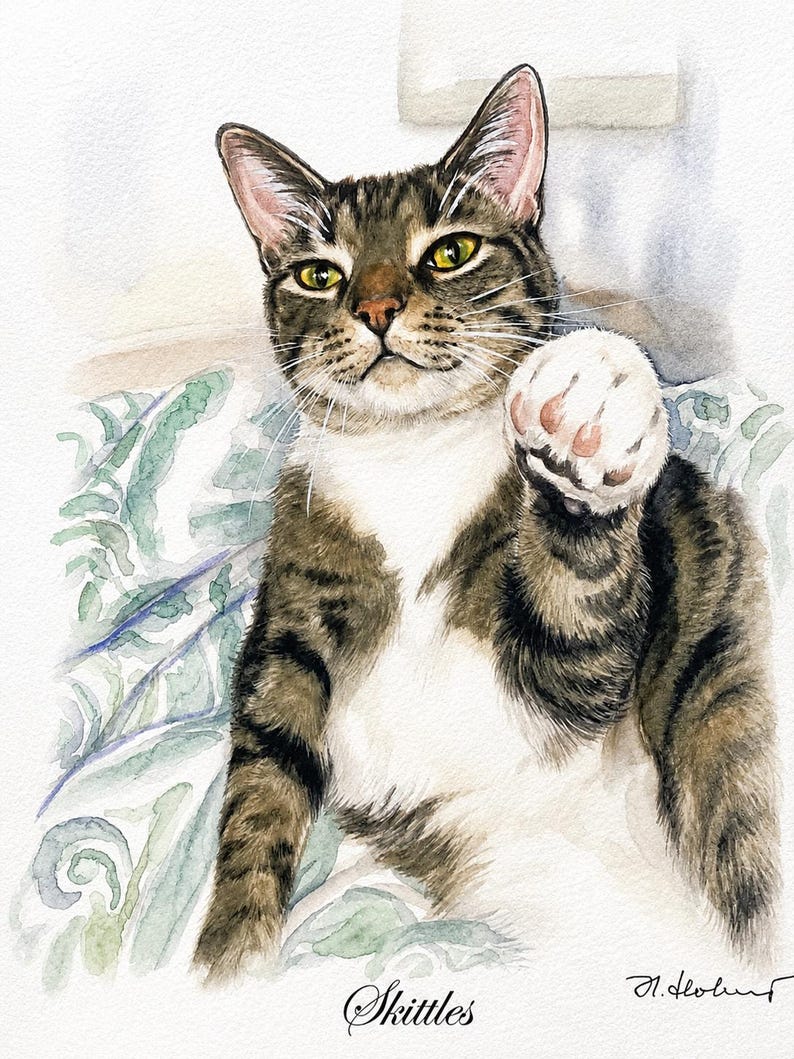 A watercolor painting of a brown and black tabby cat with a white chest and paws. The cat is reaching forward with one paw raised. The name Skittles is written in cursive at the bottom center, with a signature in the bottom right corner.