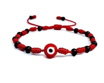 May include: Red string bracelet with black beads and a blue and white evil eye charm.