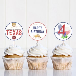 May include: Three cupcakes decorated with Texas-themed cupcake toppers. The toppers feature a red, white, and blue Texas flag with the number 4, a white circle with the text "Happy Birthday" and an armadillo, and a white circle with the text "Deep in the heart of Texas" and a drawing of a can of Dr Pepper.