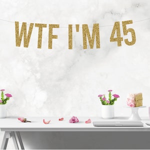 May include: Gold glitter banner with the text "WTF I'M 45".