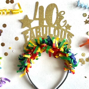 May include: Gold glitter headband with the text "40 & Fabulous" and colorful streamers.