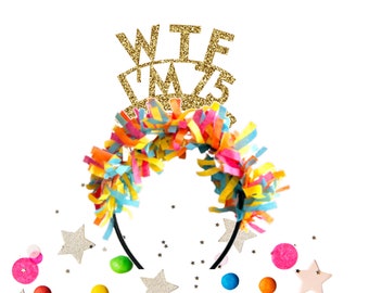 May include: A gold glitter headband with the text "WTF" and "'MAS" on it. The headband is decorated with colorful streamers and is surrounded by confetti.