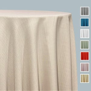May include: A close-up of a beige round tablecloth with a textured weave. The fabric drapes over the edge of a table. Color swatches of gray, teal, white, green, red, lavender, and yellow are shown on the right.