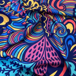 May include: A colorful fabric with a psychedelic pattern featuring swirls, lines, and dots in shades of blue, pink, yellow, and red on a dark blue background.