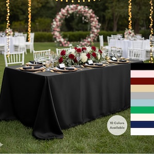 May include: A black rectangular tablecloth covers a table set for a formal event. Gold-rimmed plates, black napkins, and gold cutlery are arranged. A floral centerpiece of red and white roses sits in the middle. The image shows a variety of colors available.