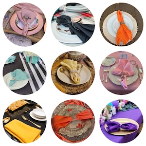 May include: Nine different table settings featuring a variety of coloured napkins folded in different ways. Each setting includes a plate, charger, and cutlery. The napkins are folded into a range of shapes, including a fan, a bow, and a simple fold.