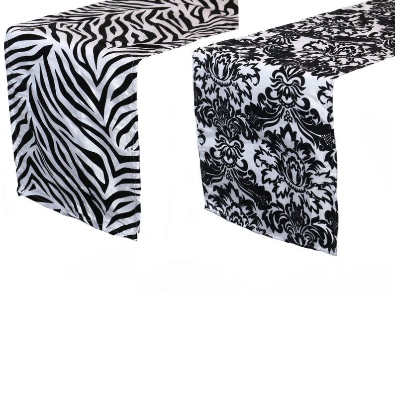 May include: Two table runners, one with a black and white zebra print and the other with a black and white damask pattern.
