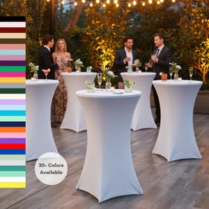 May include: White spandex cocktail tables at an outdoor event. The tables are round with a fitted cover. The image shows several tables with guests in the background. The text "30+ Colors Available" is in a white circle.
