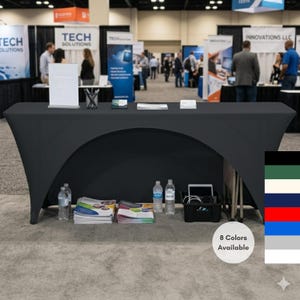 May include: A black fitted trade show table cover with an arched front. The table is set up at a convention with brochures, water bottles, and a tablet. The image shows 8 color options available.