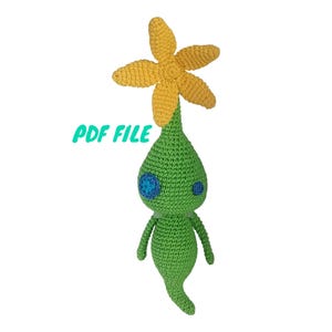 May include: Crocheted green and yellow plush toy with a flower on top. The toy has blue eyes and a long, thin body.  PDF FILE.
