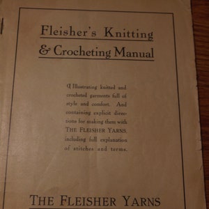 Puede incluir: Una portada de libro vintage para el Manual de tejido y ganchillo de Fleisher. La portada es beige con texto negro. El libro presenta instrucciones para hacer prendas tejidas y de ganchillo con hilos Fleisher.